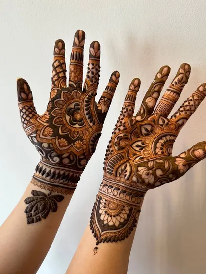 A unique design with different patterns on each hand. One features a bold mandala, while the other has a more traditional floral and leaf design, perfect for a bride who wants variety.