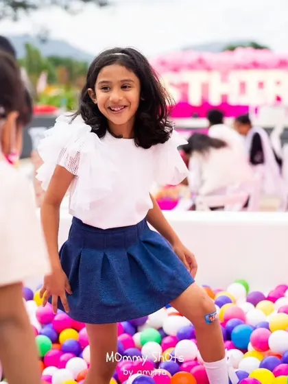A happy guest enjoying the colorful ball pit at a princess-themed party. I always ensure there are plenty of fun activities to keep the young guests entertained.
