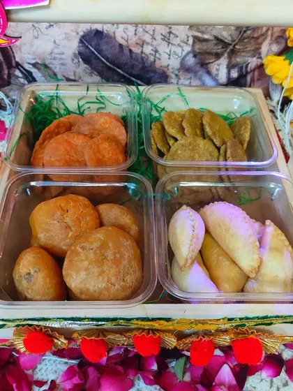 A complete Holi hamper with four different types of snacks. It includes beetroot mathri, spinach mathri, dal kachori, and gujiya, offering a perfect mix of flavors.