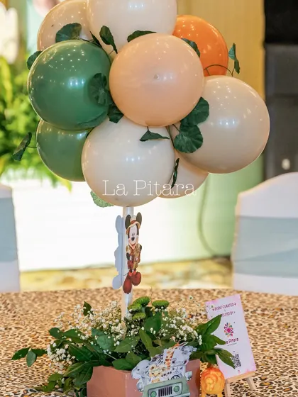 Another example of a safari-themed table centerpiece, using earthy-toned balloons and a Mickey Mouse character stick.