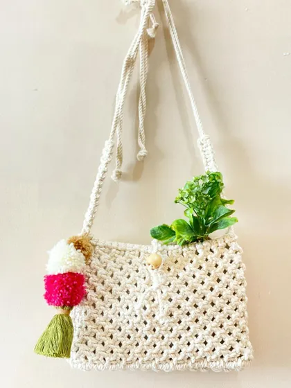 This is my happy-go-lucky bag. The natural cream color provides a perfect canvas for the fun, multi-colored pom-pom and tassel, adding a pop of playful color.