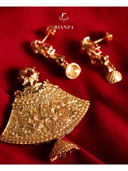 An example of gold embossing work in a temple jewellery pendant and earring set. The detailed floral motifs give a new dimension to traditional ethnic wear.