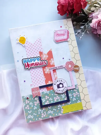 The cover of a large A4 farewell scrapbook, decorated with "Happy Memories" and "Keep Moving Forward" stickers.