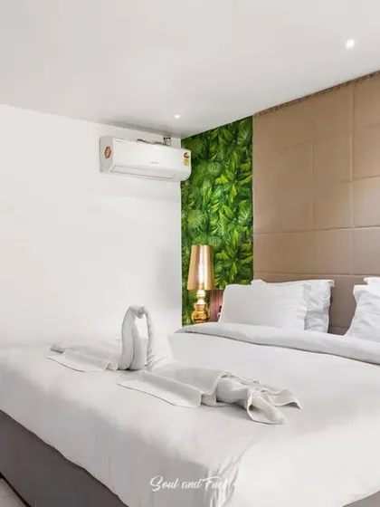 Another angle of the hotel room, showing the balance between the bold green wall and the neutral, calming elements of the space.