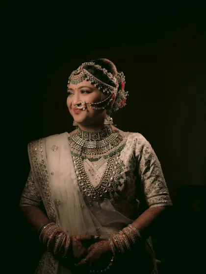 A stunning low-light portrait of a bride in her white lehenga, looking like royalty.