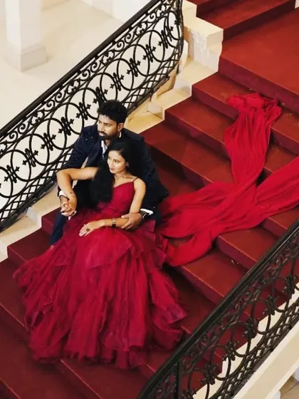 This overhead shot highlights the incredible trail of the red gown, cascading down the stairs. It's a perfect example of how I help couples create truly cinematic pre-wedding photos.