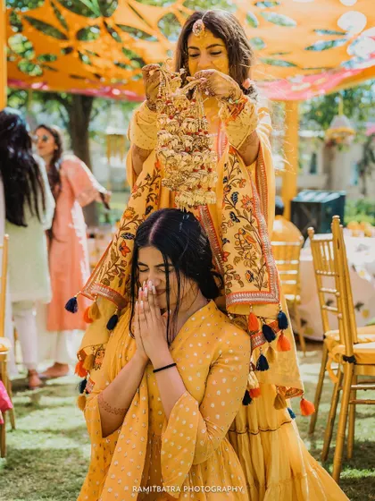 A classic shot of the Kaleerey ceremony, where the bride shakes her bangles over an unmarried friend's head.