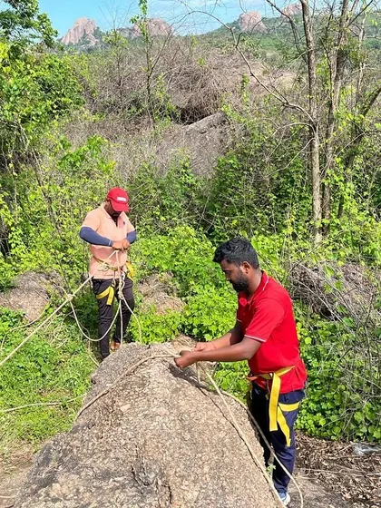 Two climbers work together to set up a safe and redundant anchor system.