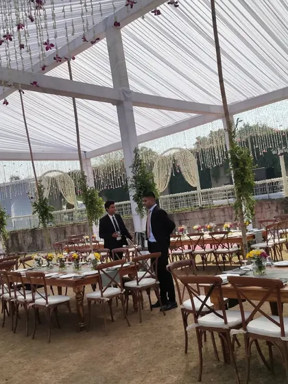 Another view of the guest seating at a farmhouse wedding, showing long community style tables. This setup is great for encouraging guest interaction during the wedding feast.