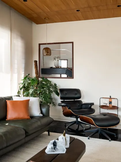 A cozy corner in a family lounge at Timber Edge, featuring classic mid-century modern furniture and warm, layered textures.