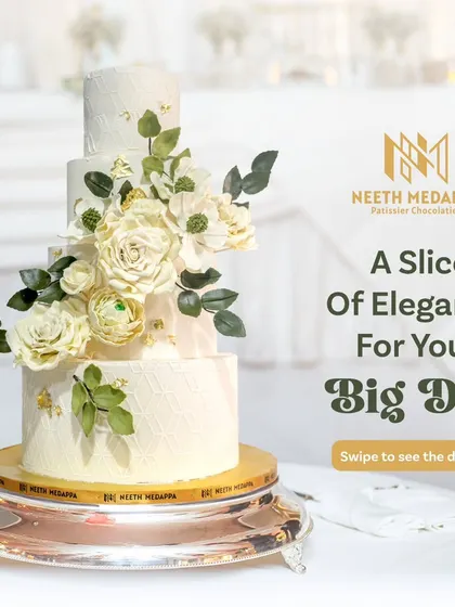 A slice of elegance for your big day. This four-tiered wedding cake features a subtle textured finish and is adorned with beautiful, handcrafted white sugar flowers and leaves, creating a timeless and sophisticated look.
