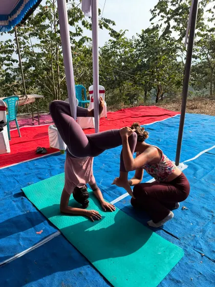 A hands-on adjustment to help a student find the correct alignment and feel more secure in an aerial pose. Safety and proper form are my top priorities.