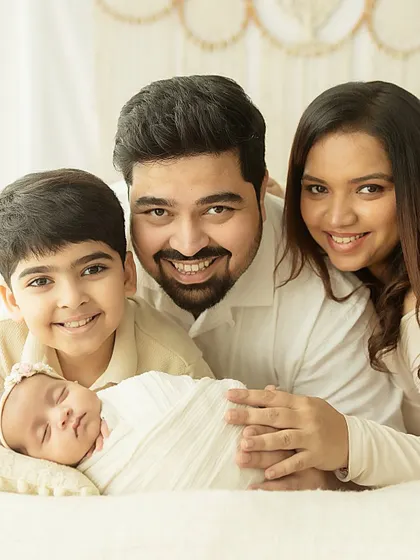 The complete family, smiling for the camera. A beautiful, bright, and happy portrait that captures the joy of a new addition.
