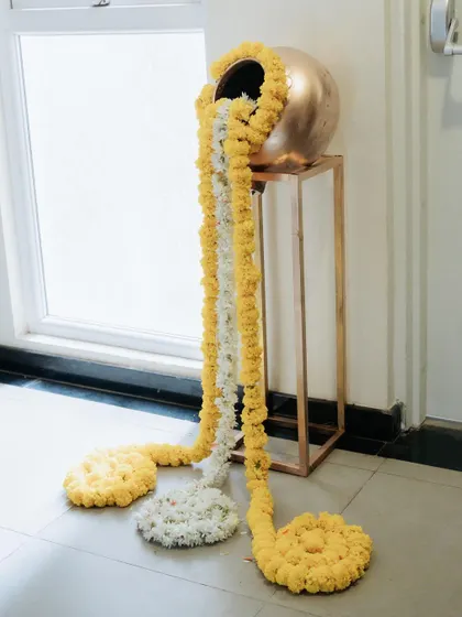I use traditional elements like this decorative pot with overflowing marigold garlands to add an authentic and auspicious feel to housewarming and festival decorations.