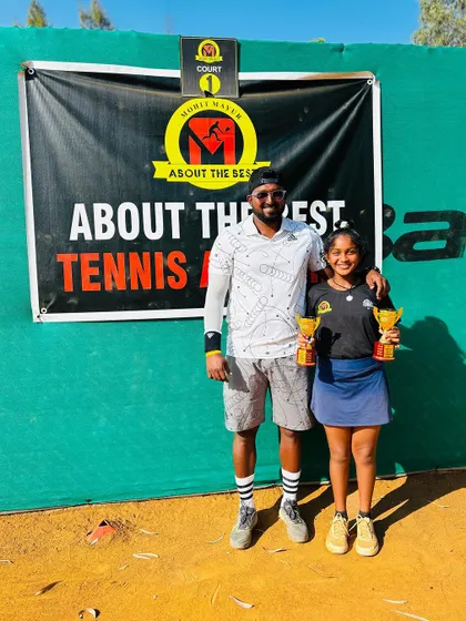 Eshitha with her coach after her double title win.