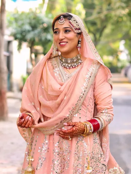 A candid moment of the bride. Her makeup is soft and radiant, designed to look beautiful in natural light and capture her happy emotions.