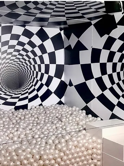 An interactive ball pit combined with a dizzying optical illusion backdrop creates a fun and disorienting photo experience. This type of custom illusion booth is perfect for brand activations that want to stand out.