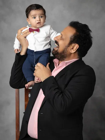 A grandfather's joy is infectious in this playful portrait with his grandbaby. These candid moments of laughter are truly precious.