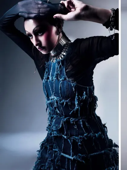 A close-up shot focusing on the intricate, deconstructed denim texture of the gown. This image highlights the craftsmanship of the garment while maintaining a moody, artistic feel.