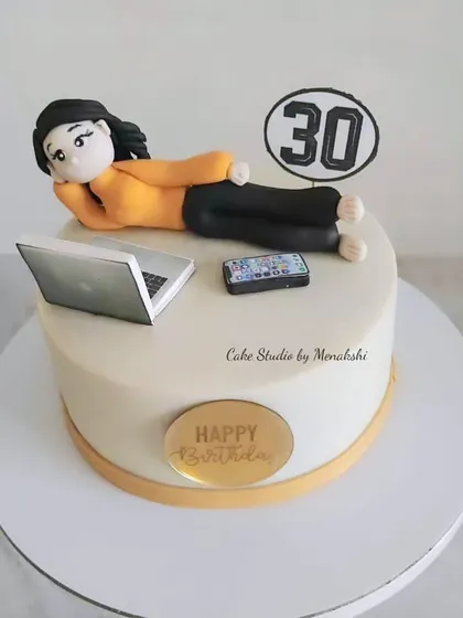 A special 30th birthday cake for a workaholic. The design shows her relaxing with her laptop and phone, a perfect theme for a milestone birthday.