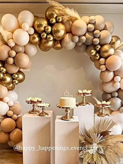 This chic and neutral-toned boho setup shows our love for sophisticated palettes. A flowing balloon arch in beige, brown, and gold creates a warm and inviting space for the dessert display, complete with pampas grass for that perfect rustic touch.