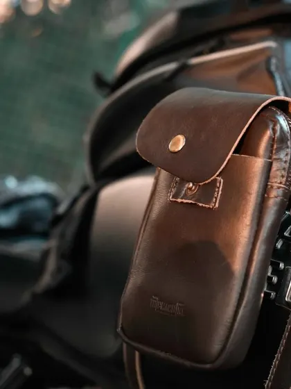 Product in-situ photography is key. This shot highlights a leather accessory pouch on a motorcycle, showing how the product integrates seamlessly into the biker's lifestyle.