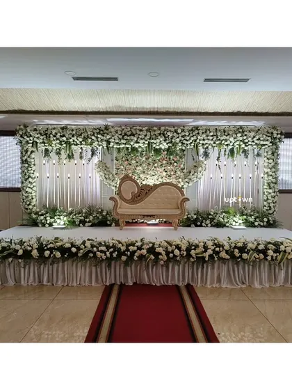 A wide shot of the all-white floral stage.