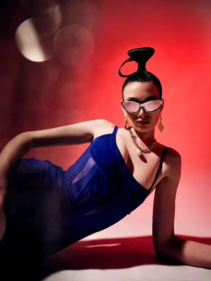 Another angle from the red-background series for the Mugler x H&M editorial. The styling focuses on creating strong lines and a sense of movement, with the sculptural hair adding to the avant-garde feel.