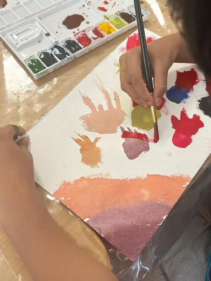 A close-up of a child painting what he described as "asteroids falling on the sun." We love listening to the stories behind the art, as it reveals their incredible imagination.