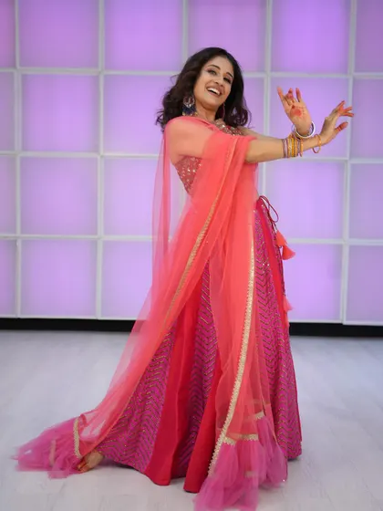 A full, twirling shot that captures the vibrant energy of this pink lehenga.