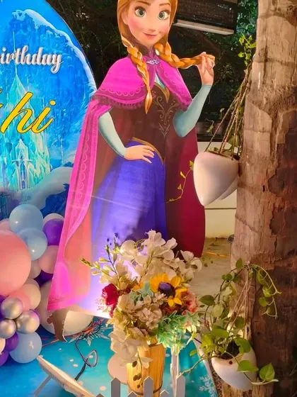A life-size cutout of Anna from Frozen, used as part of the party decor.