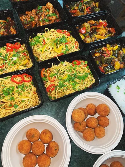 An Asian feast packed for a house party. This delivery included our vegetable hakka noodles, chili chicken, and crispy arancini balls.