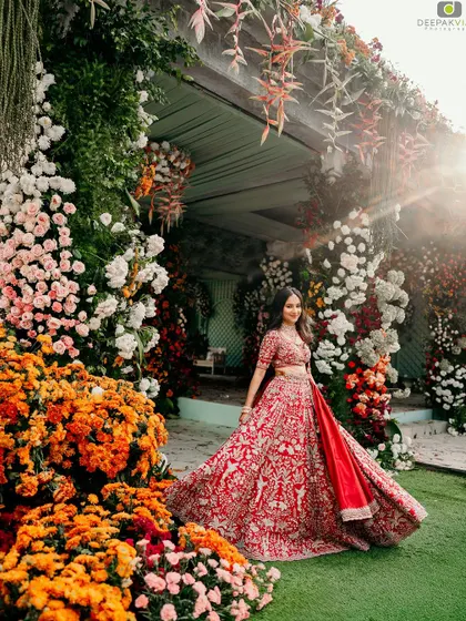 A breathtaking shot of my bride Punya at her engagement. The vibrant red lehenga and the grand floral decor are perfectly matched by a radiant and classic makeup look, creating a truly unforgettable bridal portrait.