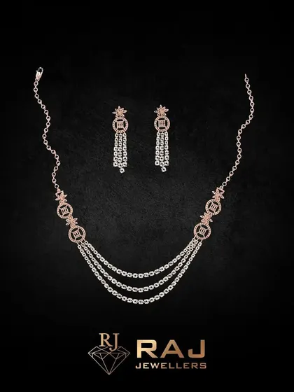 A delicate triple-strand necklace crafted from fine chains and accented with small, sparkling motifs. This piece offers a layered look in one, perfect for adding a touch of sophisticated sparkle.