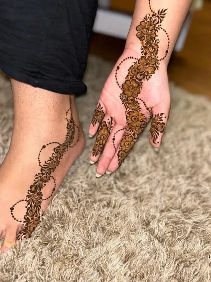 An aesthetic and minimalist design featuring a simple floral vine on the hand and foot. It’s a beautiful example of "less is more."