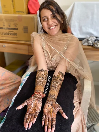 The bridal glow is real! A happy bride showing off her full traditional henna, complete with doli and baraat figures, ready for her big day.