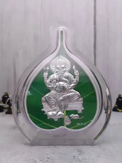 Yeh 999 pure silver Ganesha ka chitra hai, jise ek paan ke patte ke aakar ke frame mein banaya gaya hai. Yeh Ganesh Chaturthi par gift dene ke liye ekdum sahi hai.