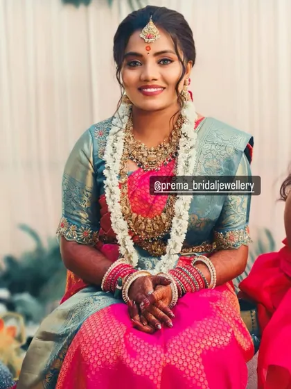 A beautiful seated portrait of a bride wearing a temple jewellery set.