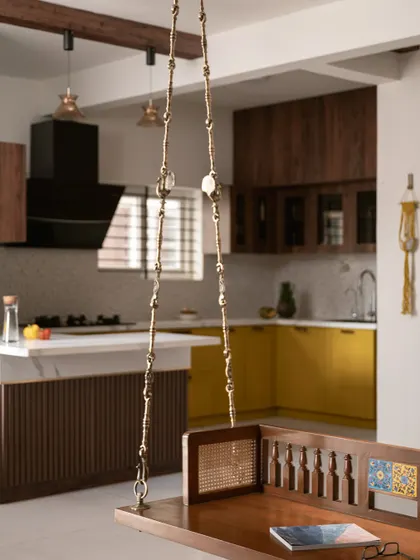 This view from the living area shows how the kitchen, with its dark wood overhead cabinets, connects to the home's traditional theme. The breakfast bar extension serves as the primary dining space.