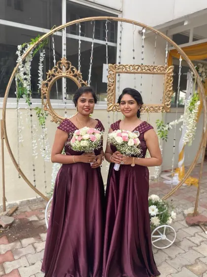 Beautiful bridesmaids in matching wine-colored satin gowns. We love coordinating outfits for the entire bridal party.