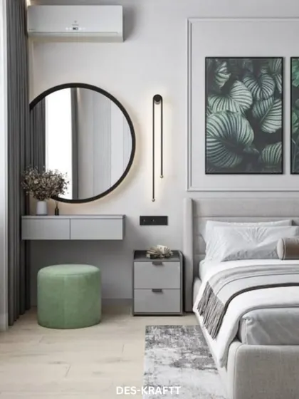 This angle showcases the functional vanity area, with a large round mirror, floating desk, and a pop of color from the soft green stool. Botanical art adds a natural touch.
