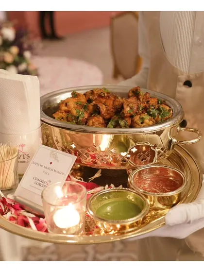 A tray of delicious Chicken Seekh Kebabs served in a traditional brass dish with mint and tamarind chutneys.