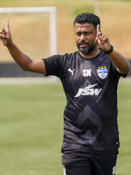 A coach directs his players during a training session, his gestures conveying the strategic instructions needed to elevate their game.