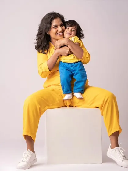 A mother and son in matching bright yellow outfits, sharing a hug. This photo is full of vibrant color and pure happiness.