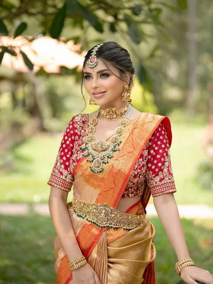 A beautiful portrait of the model, showing the complete look with the traditional updo, jewellery, and saree styling.
