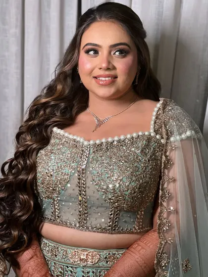 The half-up style keeps the hair away from the face while allowing the long waves to cascade down her back.