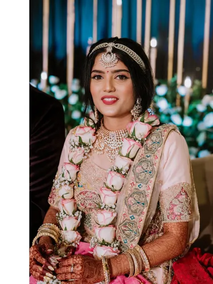A solo portrait of the bride on her reception stage, wearing a beautiful garland.