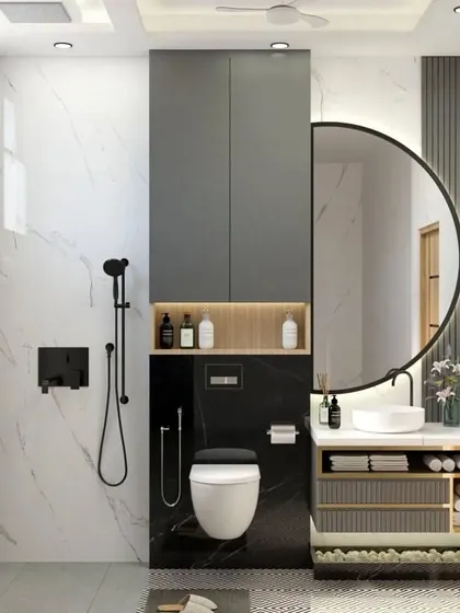 A contemporary bathroom design with a black and white theme. The space features a large round mirror, a wall-mounted toilet, and a tall storage cabinet, all set against a backdrop of white marble-patterned walls.