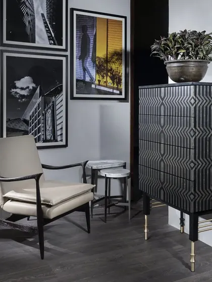 The Laila Chest of Drawers from our Koko collection is a luxurious statement piece. The drawer fronts are embellished with a geometric pattern of gold pyrite and black resin, set within a solid teak wood frame with elegant brass accents.
