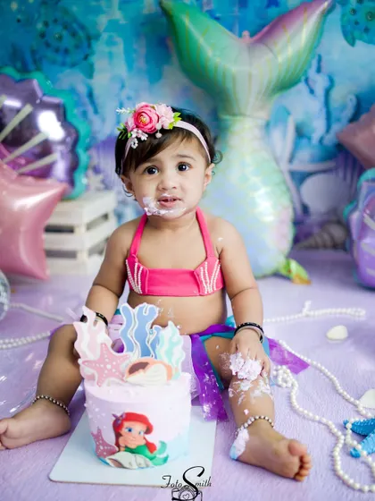A messy and magical mermaid cake smash. The custom cake and underwater theme create a fantastical scene for this little one's first birthday celebration.
